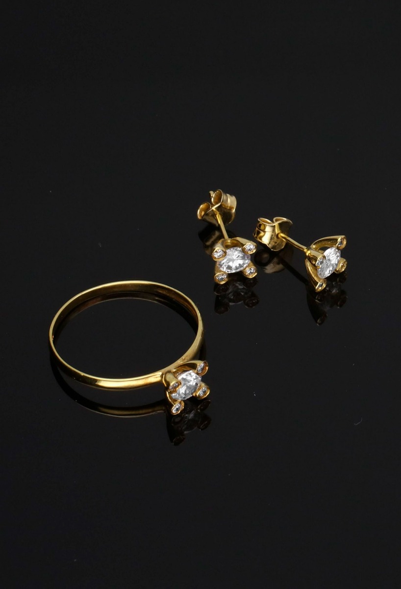conjunto pendientes y sortija oro amarillo 18 ktes con circones toma sobre fondo negro sin recortar