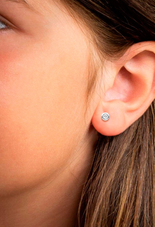 Pendientes tipo chatón oro blanco 18k y diamantes 243_HOO-AAHRL pendientes oro y diamantes tipo chatones con sistemas de presion perfectos para niñas, mujeres y hombres foto en modelo niña para exposicion en web el rubi joyeros