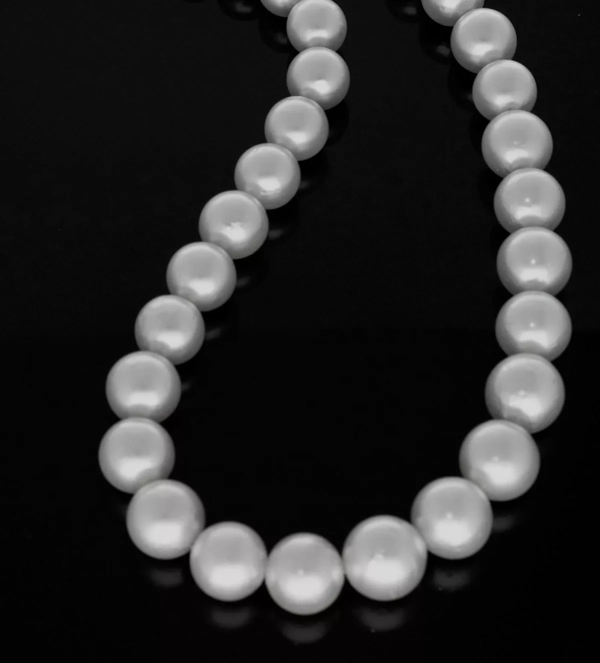 Hilo de perlas australianas degradee collar de perlas australianas degrade vista sobre base negra espejo