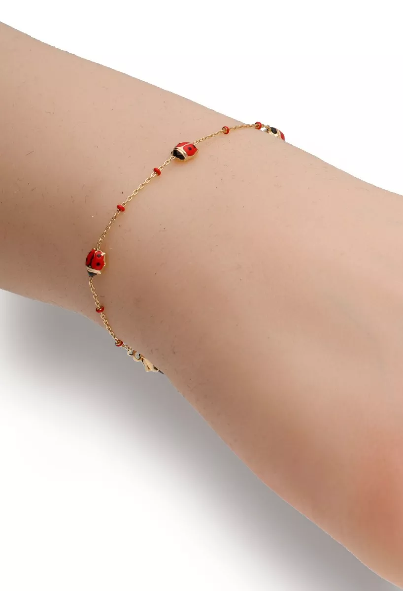Pulsera bebé oro 18k con mariquitas esmaltadas Pulsera bebé oro 18k con mariquitas esmaltadas foto muñeca modelo
