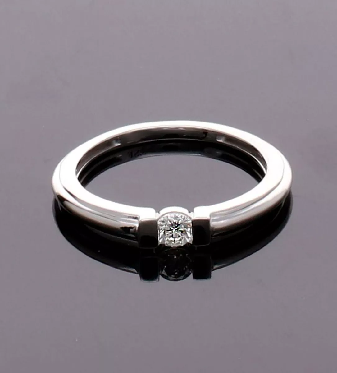 anillo de compromiso oro blanco 18 ktes con diamante talla brillante engastado a presión, fotografía sin retoques sobre fondo negro