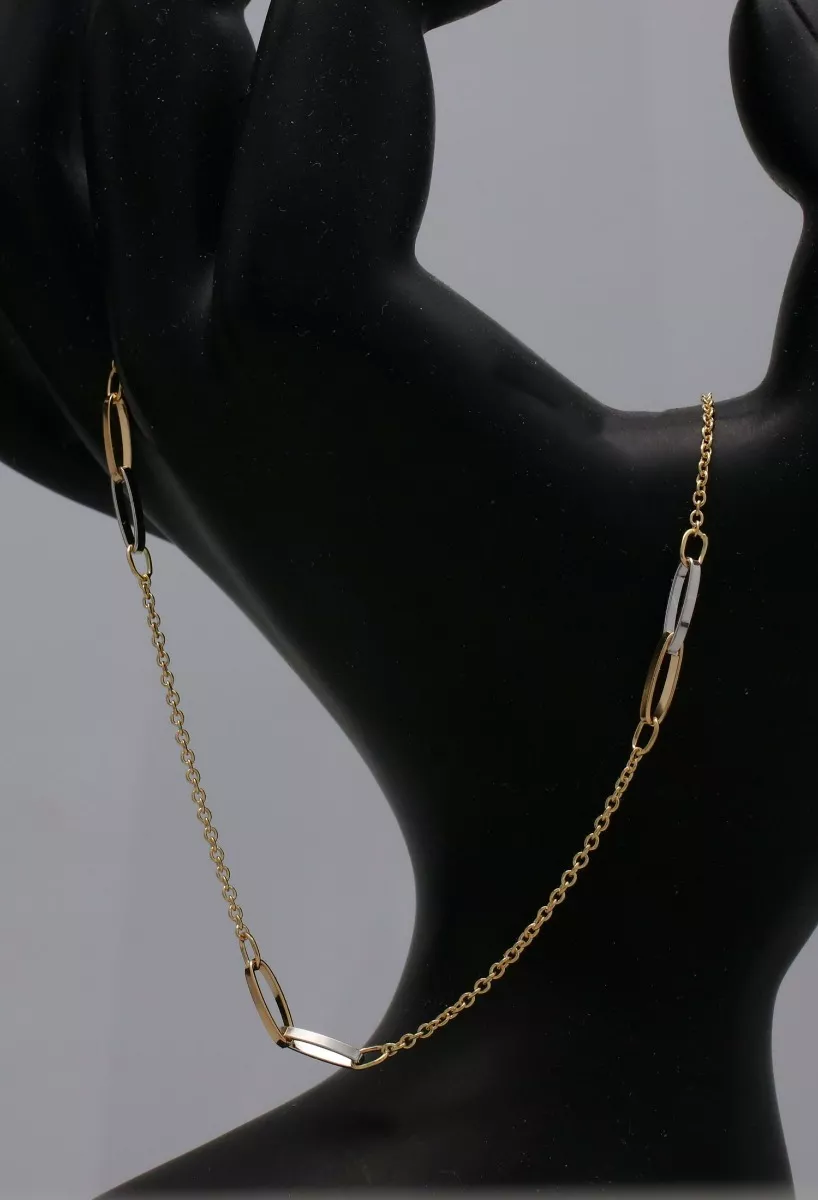Gargantilla de oro bicolor 18K. cadena forzada con entrepiezas de asas enlazadas gargantilla oro bicolor 18 ktes cadena eslabones forzados y entrepiezas asas enlazadas vista en peto de joyeria
