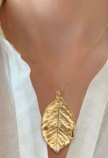 colgante hoja natural metalizada chapada oro toma con modelo femenino