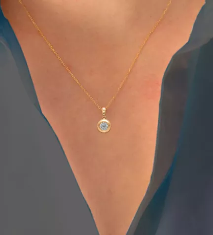 colgante de oro chaton amarillo con circon foto escote de mujer