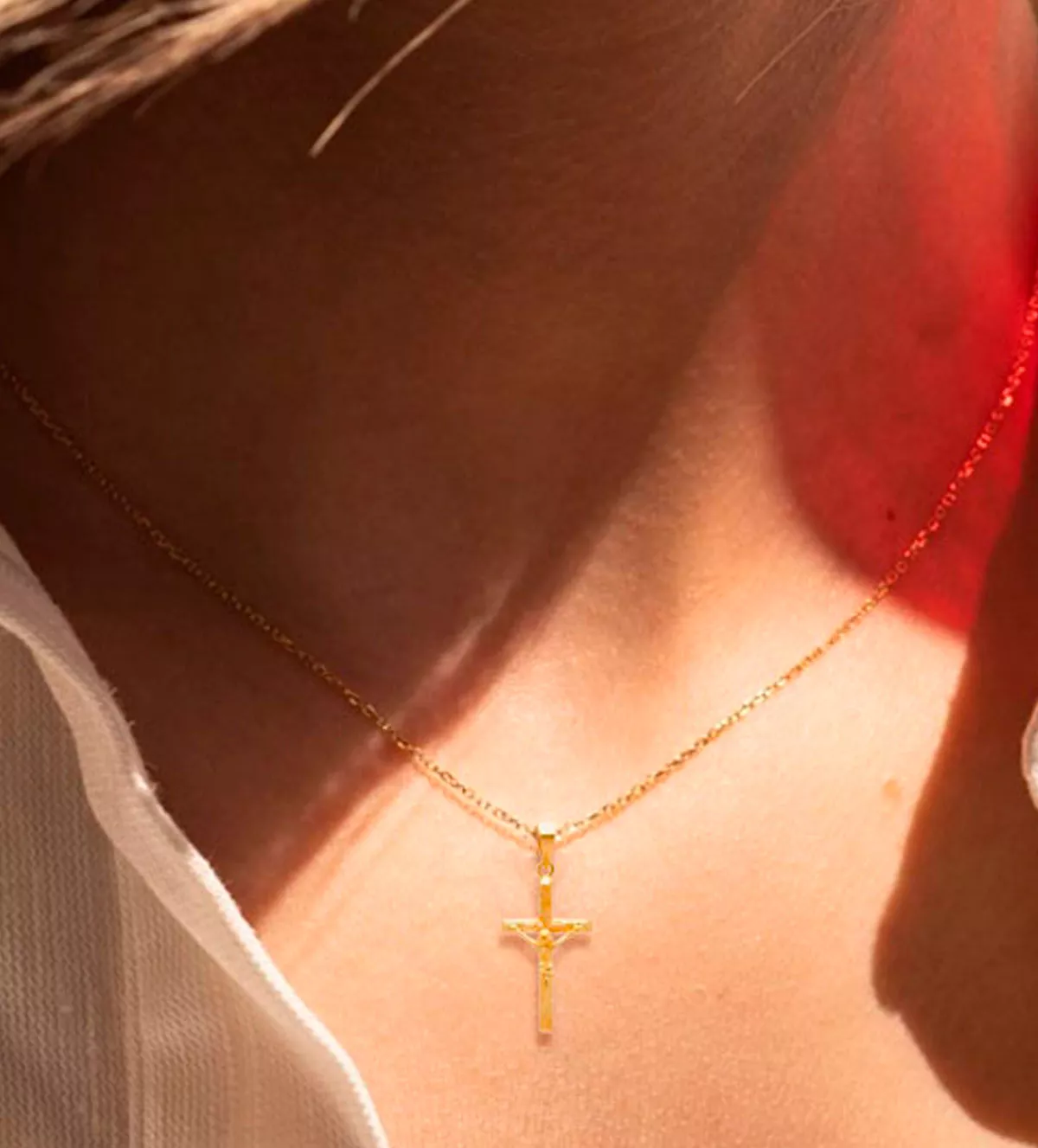 Cruz de oro amarillo 18 kilates 038_LO-034-24AM01 cruz de oro con cristo y cruz como tronco toma con modelo mujer